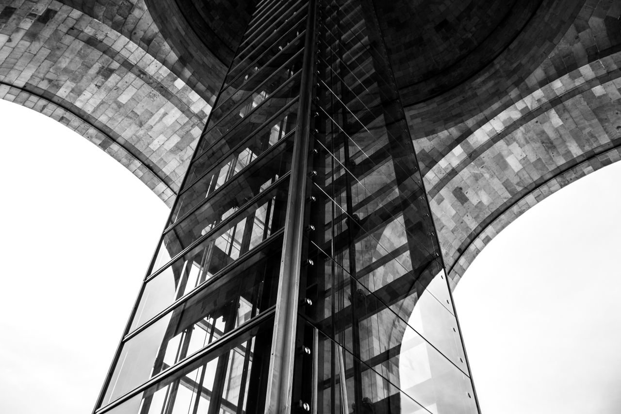 Dramatic perspective of a modern architectural structure featuring glass and stone.