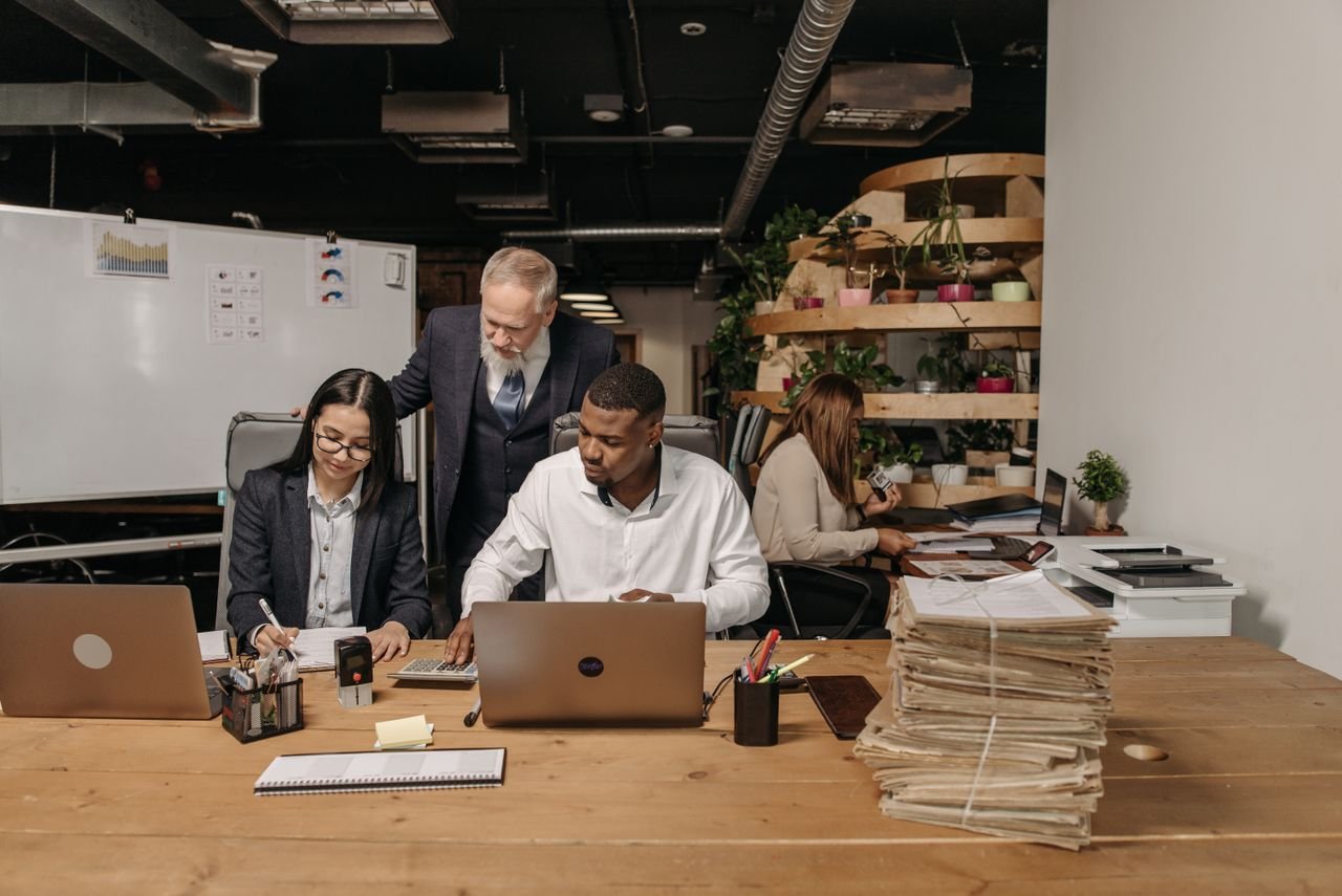 Team of professionals working collaboratively in a modern office environment with documents and laptops.
